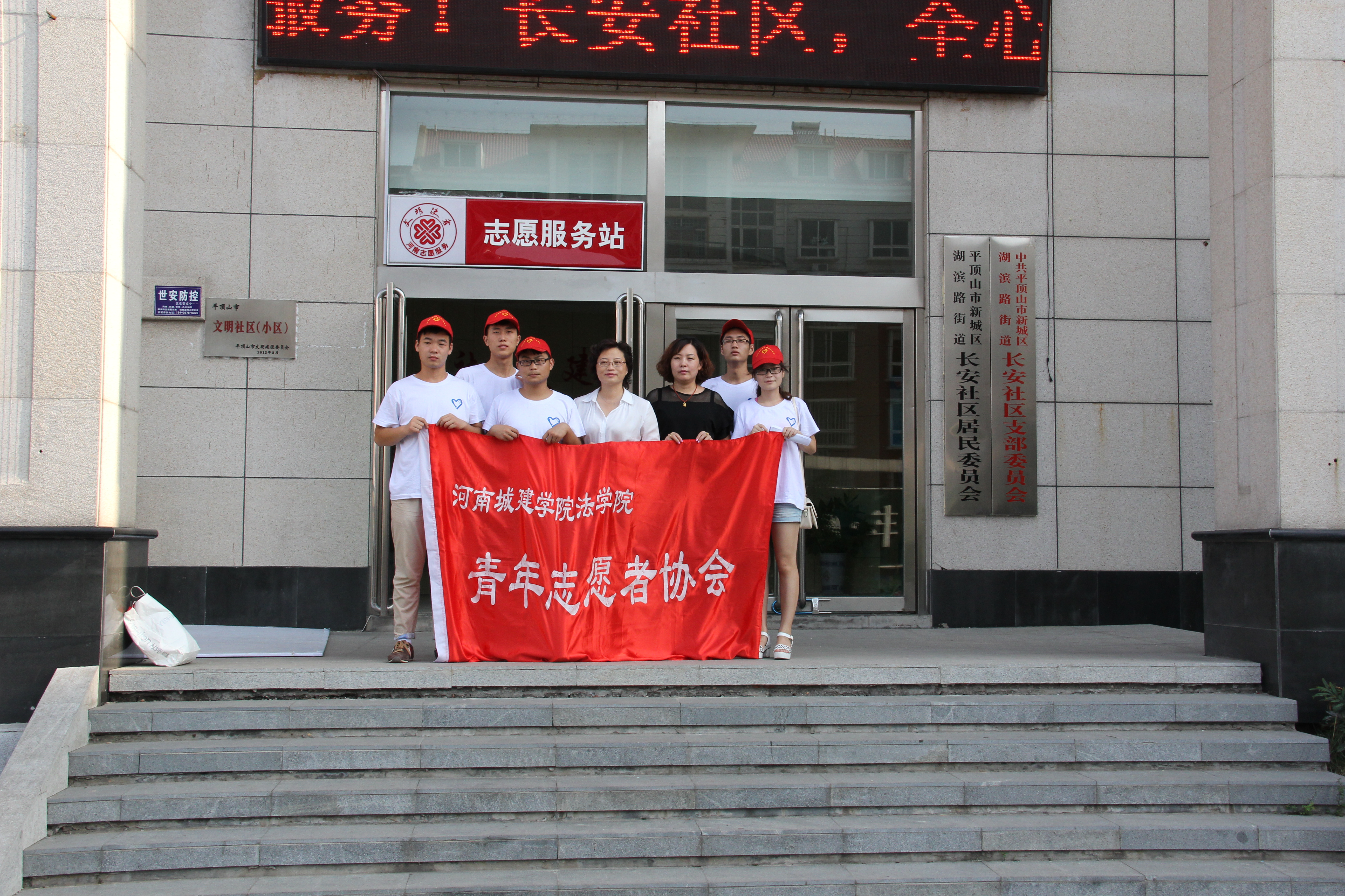 图为团队成员同社区领导合影